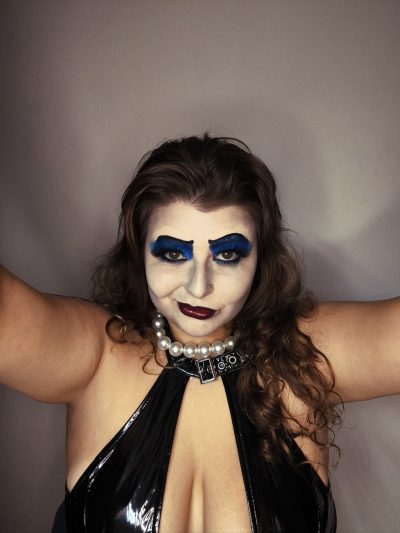 Maquillaje de Frank-N-Furter: caracterización drag con sombra de ojos azul intenso y gargantilla de perlas