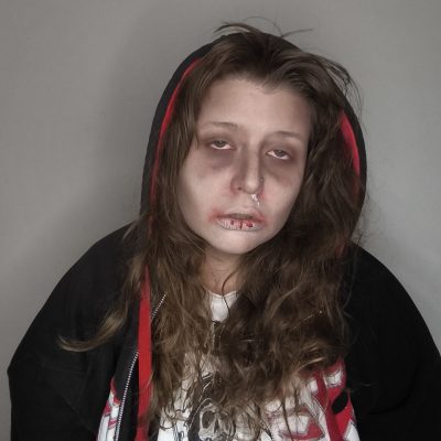 Maquillaje FX de caracterización inspirado en Euforia: ojeras marcadas, piel pálida y labios agrietados, con sudadera negra de capucha.