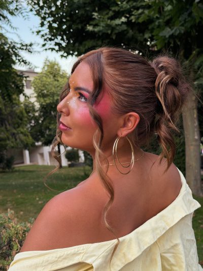 Summer Muse: plano de espalda con recogido messy bun y colorete fucsia subido hasta la sien
